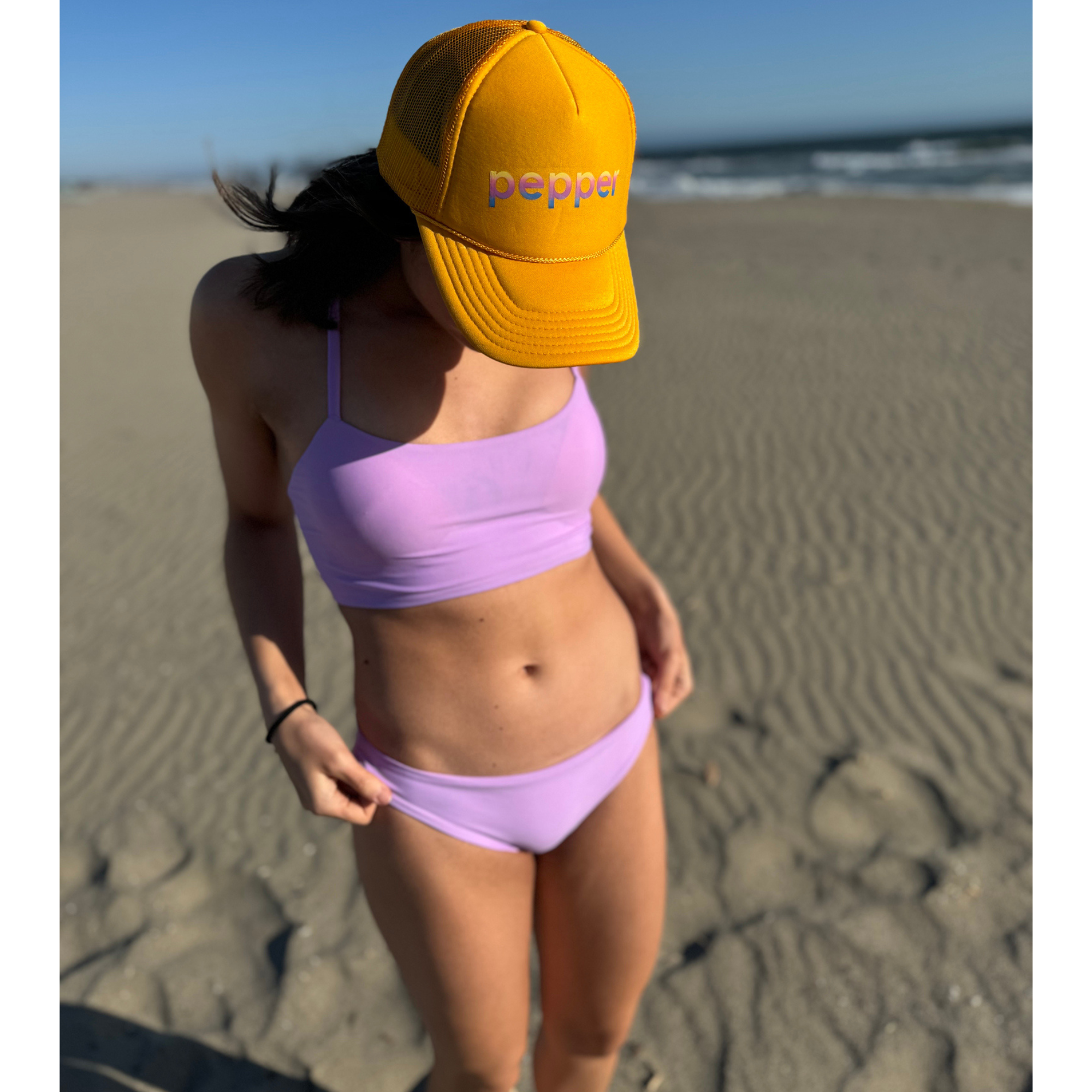Reversible Sunset Modest sport bikini bottom. Solid lilac color reverses to a colorful pastel floral print. Mid rise and comfortable for sporty athletic girls and women, great for beach volleyball and surfing. Pepper Swimwear.