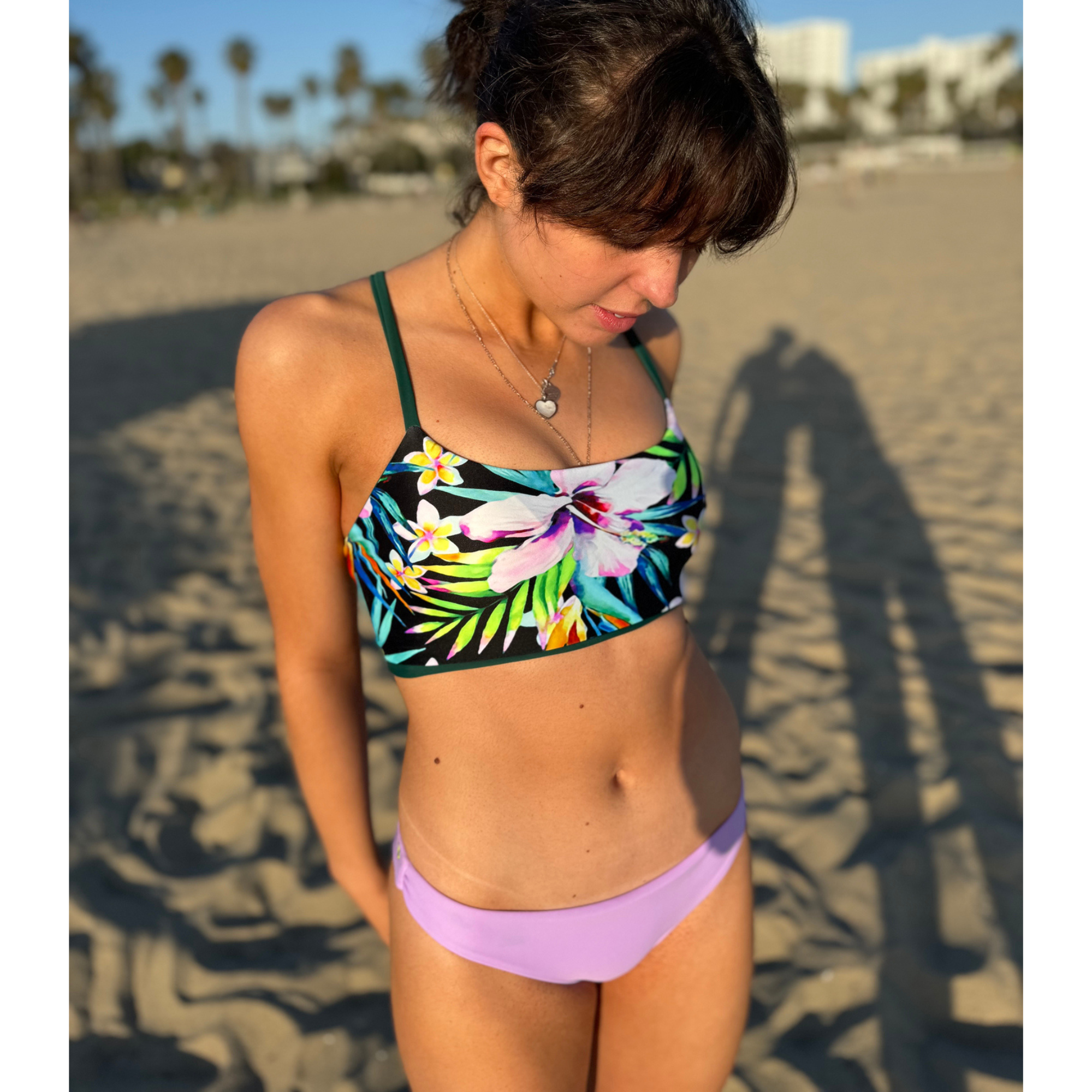 Reversible Sunset Cheeky sport bikini bottom. Solid lilac color reverses to a colorful pastel floral print. Mid rise and comfortable for sporty athletic girls and women, great for beach volleyball and surfing. Pepper Swimwear.