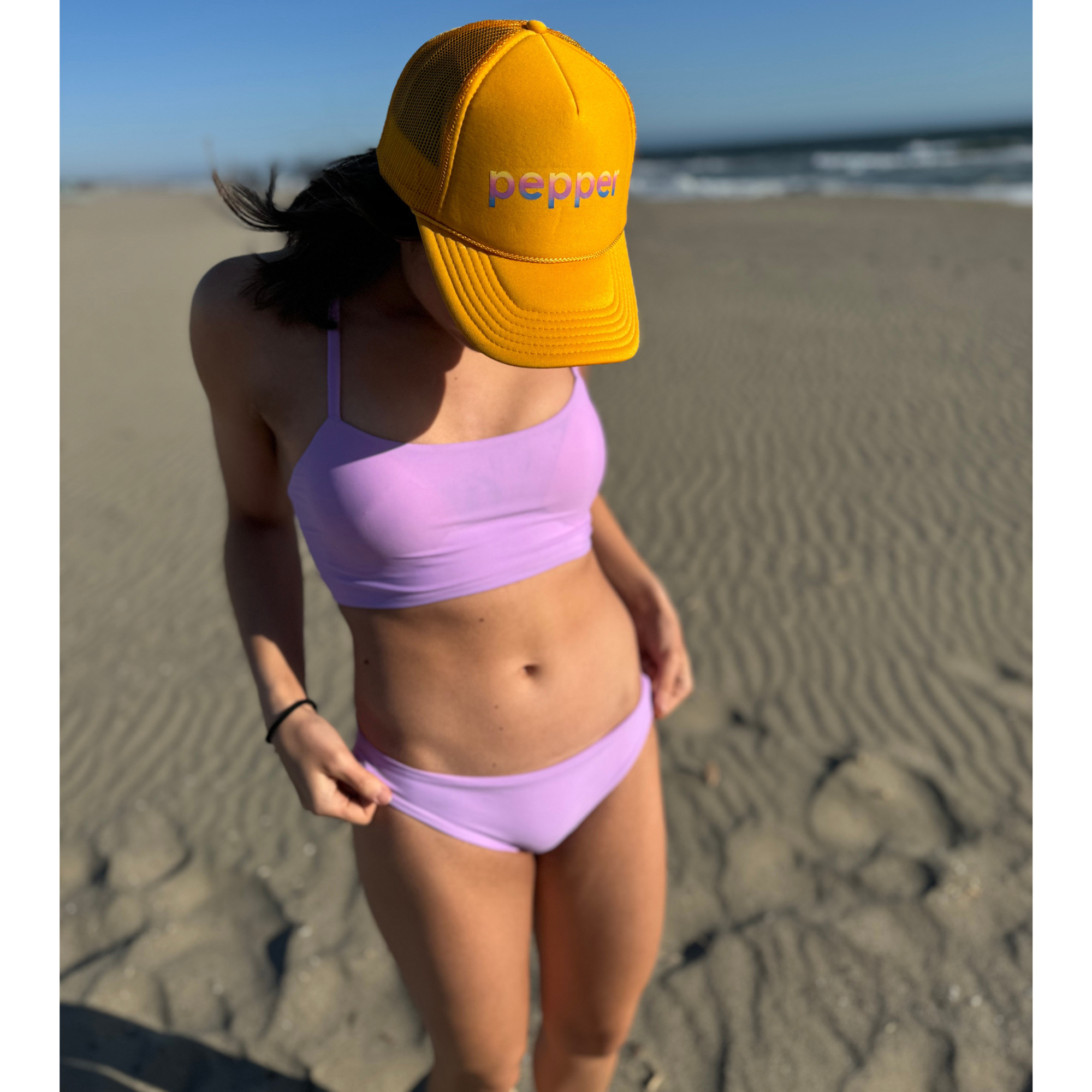 Reversible Sunset Modest sport bikini bottom. Solid lilac color reverses to a colorful pastel floral print.  Mid rise and comfortable for sporty athletic girls and women, great for beach volleyball and surfing. Pepper Swimwear.