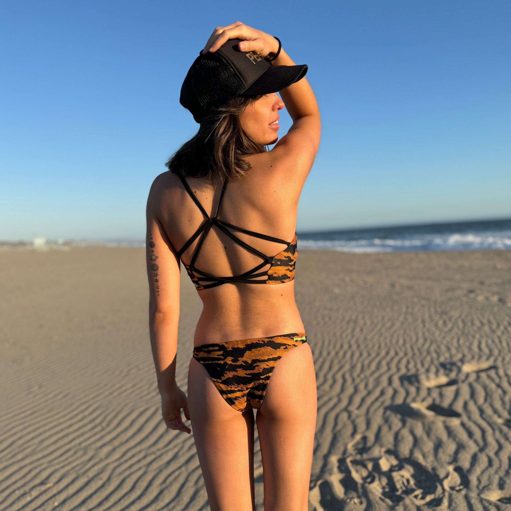 Reversible Sunset Cheeky sport bikini bottom. Custom cosmic stars and moon print reverses to a copper brown tiger print. Mid rise and comfortable for sporty athletic girls and women, great for beach volleyball and surfing. Pepper Swimwear.