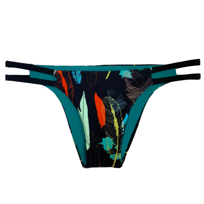 An attractive and stylish reversible sport bikini bottom featuring a colorful feather print on a black background with two black straps on the hips; reverses to a solid peacock green.