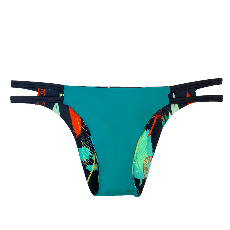 An attractive and stylish reversible sport bikini bottom featuring a solid peacock green fabric with two black straps on the hips; reverses to a colorful feather print on a black background.
