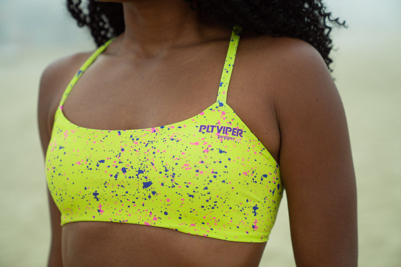 Close up of 1993 lime splatter Pitviper and Pepper collaboration top. Purple and pink splatter s on lime colored swimwear fabric